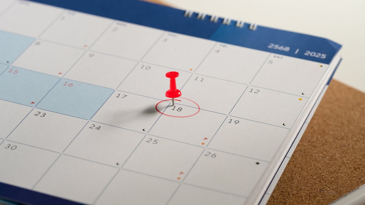 Close up of calendar with the 18th circled in red and red push pin, symbolizing an important appointment.